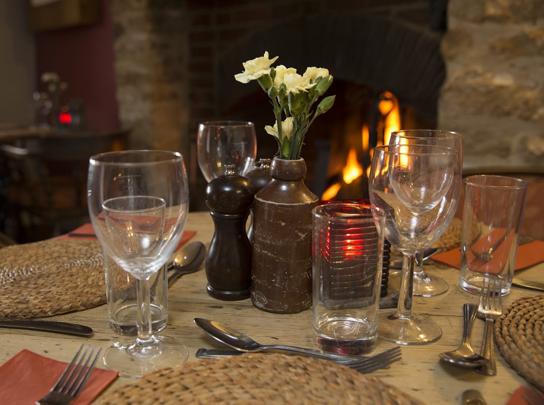 A table laid for dinner beside the open fire