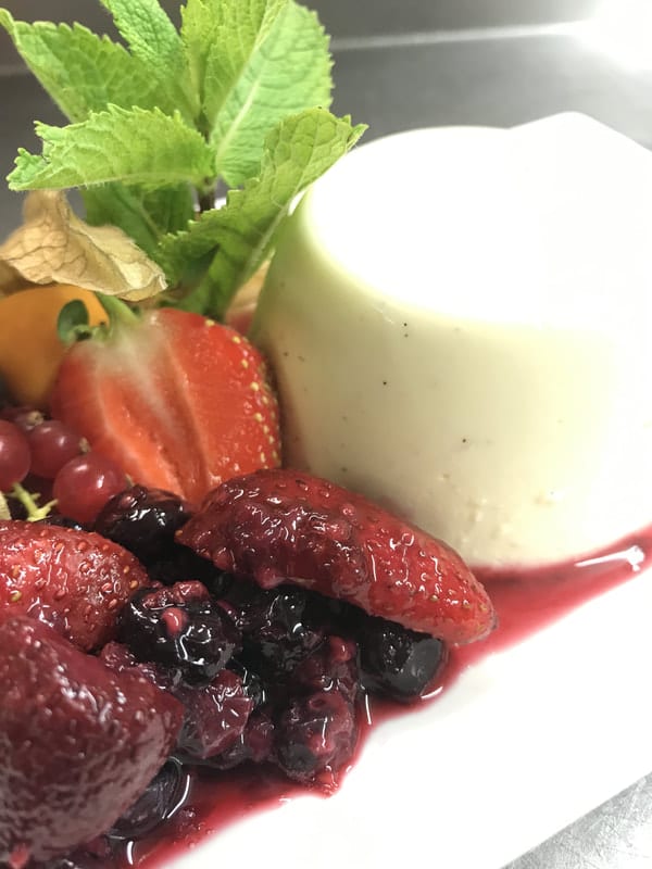 A creamy dessert with berries and fruit compote