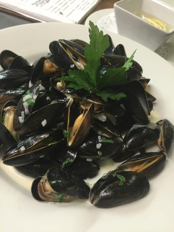 A bowl of mussels with parsley